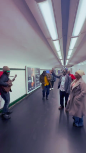 Bénéficiaires de Défi Services + applaudissant un musicien dans le métro à la station Trocadéro