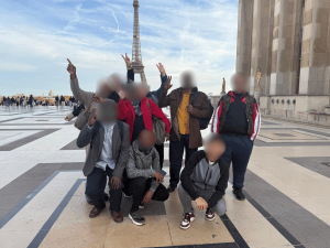 Bénéficiaires de Défi Services + prenant une photo devant la Tour Eiffel sur la place du Trocadéro avant la visite du Musée national de la Marine